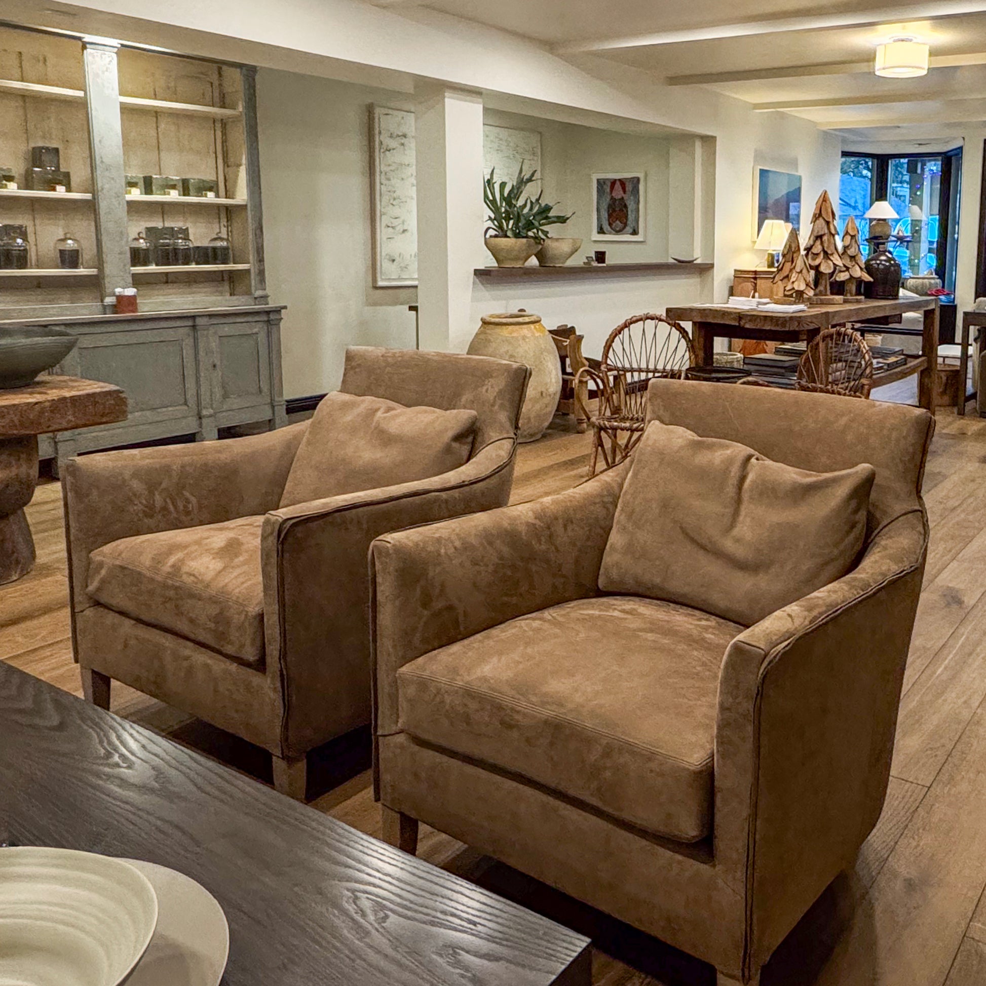 Two tan suede custom order victor chairs with plush cushions and wooden legs for comfortable seating