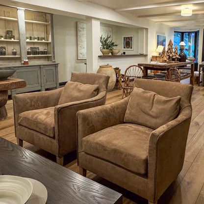 Two tan suede custom order victor chairs with plush cushions and wooden legs for comfortable seating