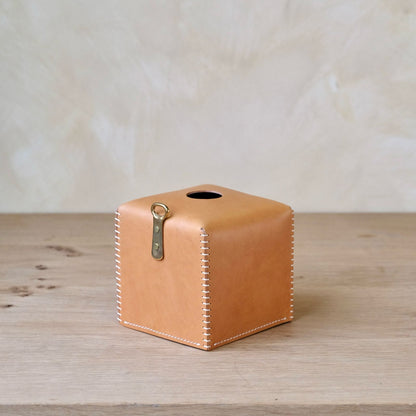 Tan leather tissue box cover with white stitching and brass clasp for stylish and durable tissue storage