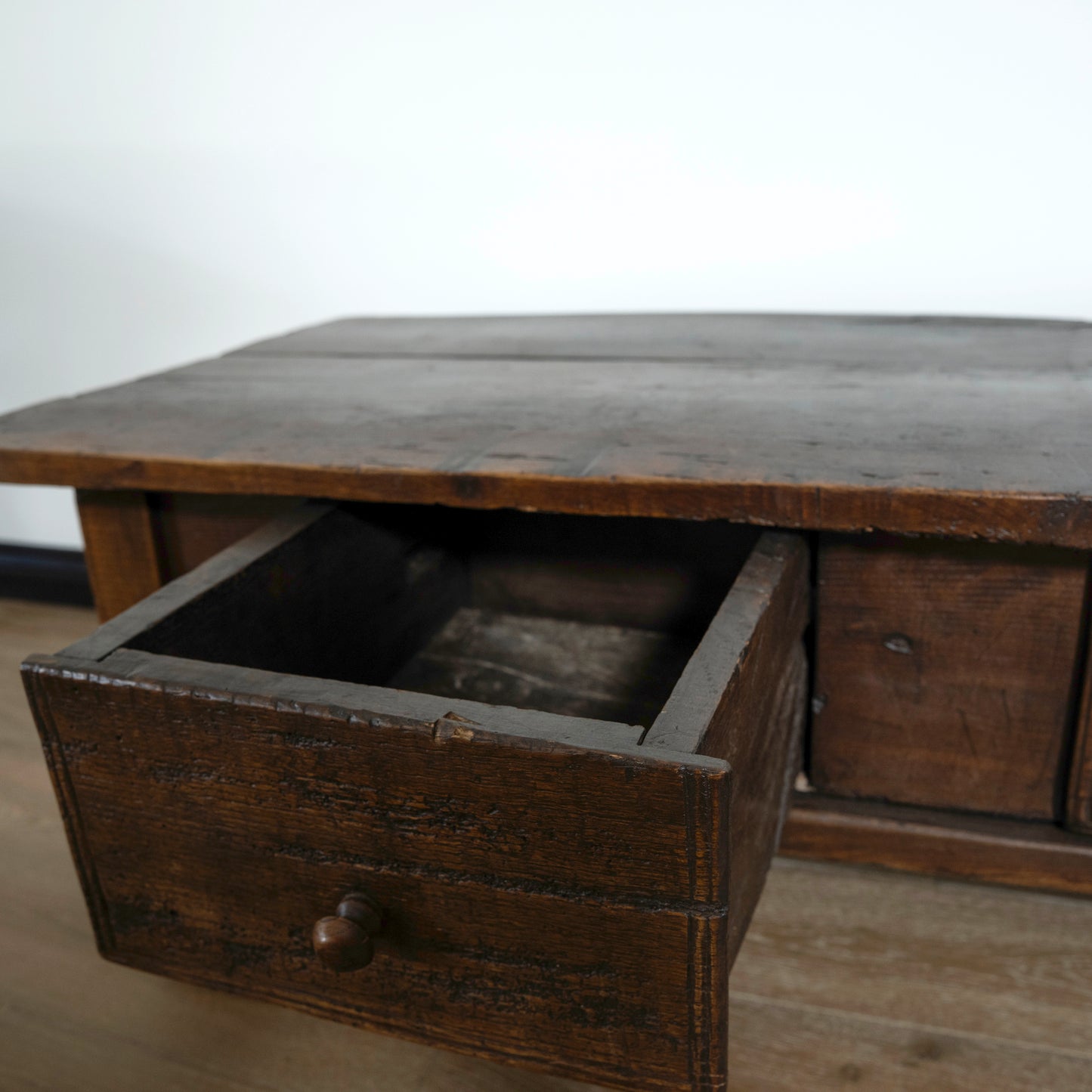 Wooden desk with an open drawer on a plain background