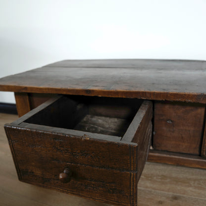 Wooden desk with an open drawer on a plain background