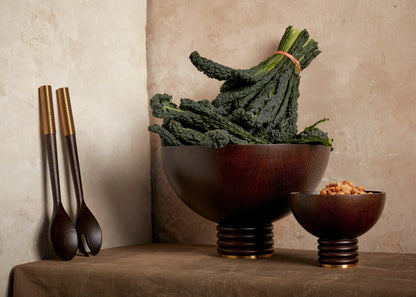Dark wood alhambra bowl with ribbed base and gold-toned rim filled with curly kale