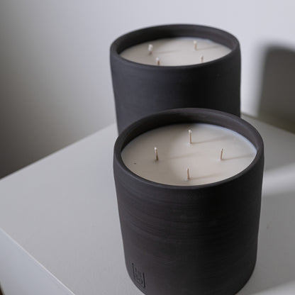 Black cylindrical candle holder with three white wicks for the candle toscana product display