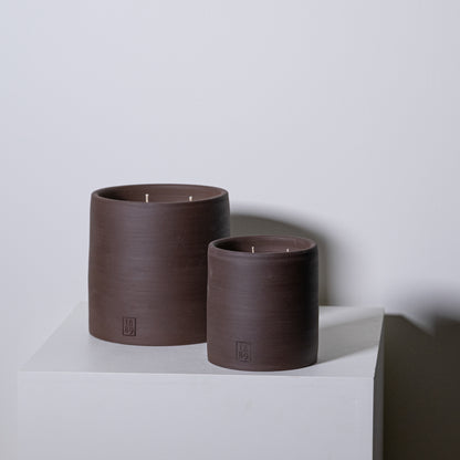 Two matte brown ceramic candle holders with three wicks each and small embossed logo base for candle Noel