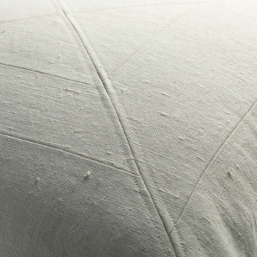 Light gray quilted fabric with stitching on vintage canvas panelled pillow showcasing textured weave detail