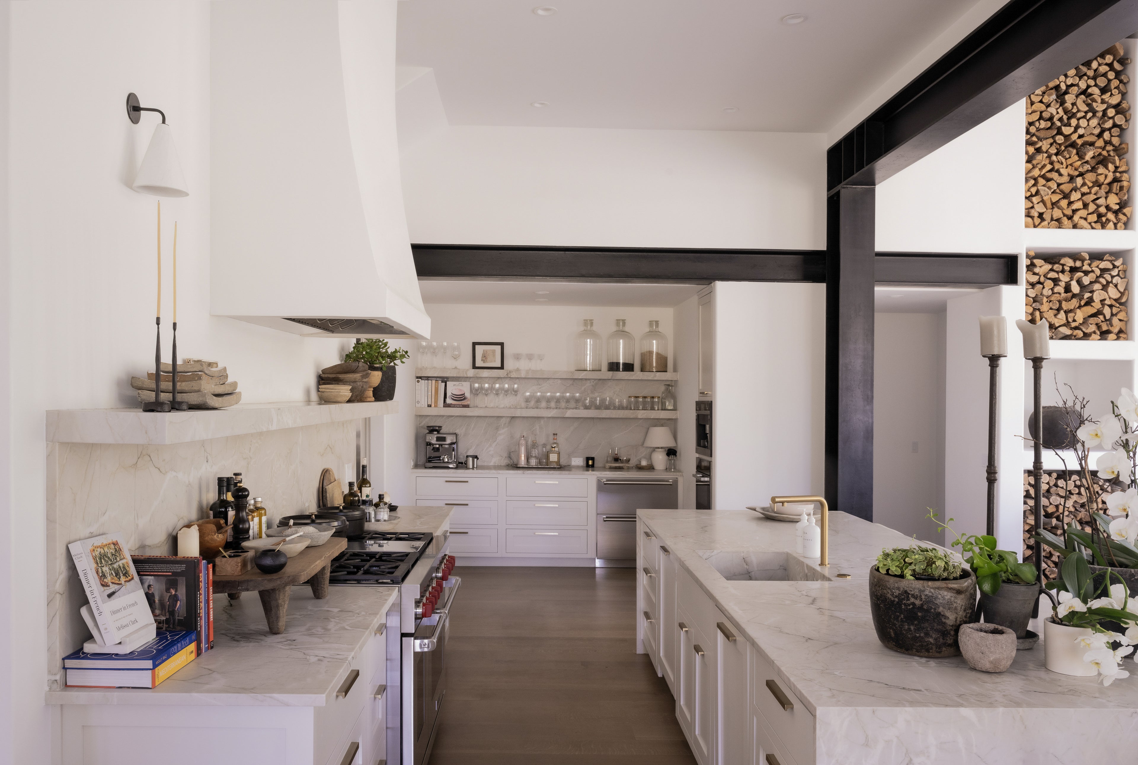 White marble kitchen island with integrated sink and gold faucet