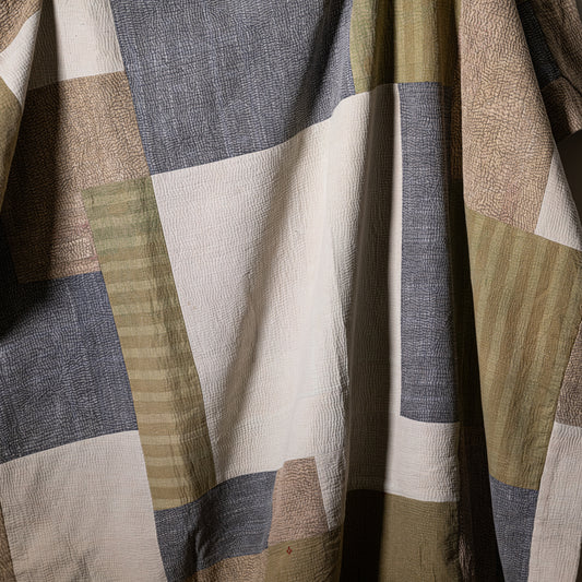 Mosaic quilt patchwork design with textured earth-toned fabric squares in beige olive green and gray