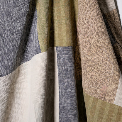 Mosaic quilt patchwork made of textured earth toned fabrics in gray beige olive green and cream shades