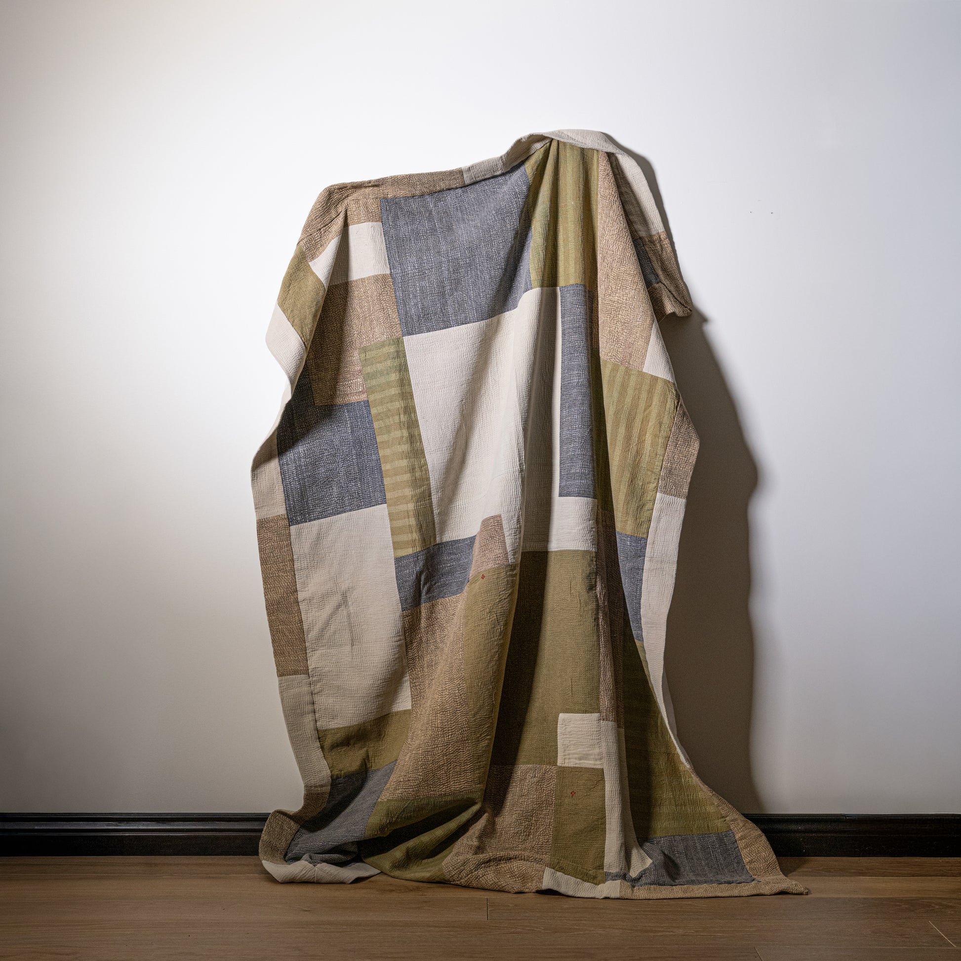 Mosaic quilt patchwork blanket with geometric pattern in earthy beige olive green and muted gray tones