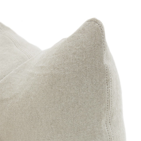 Beige linen pillow with visible stitching along its edges.