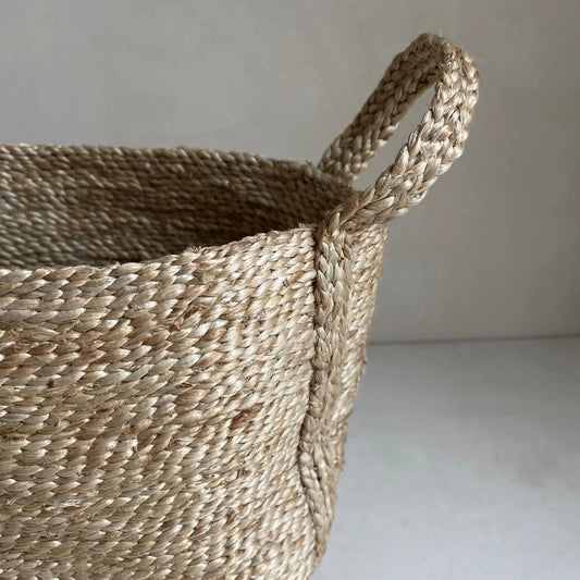 Hand woven jute basket with natural fiber weave and sturdy braided handles for durable storage use