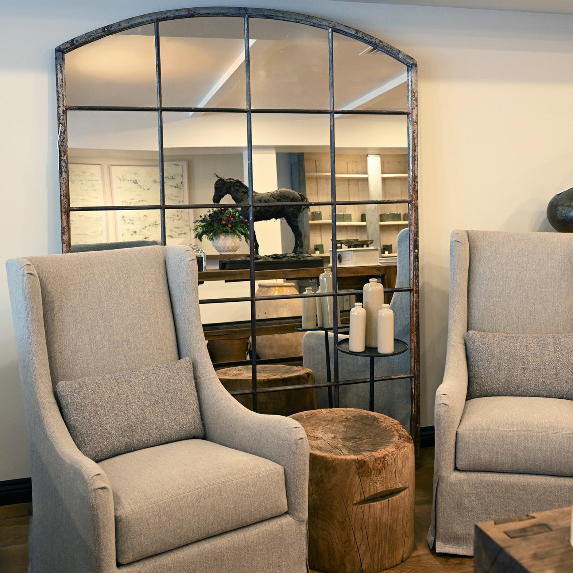 Arched window panel mirror with dark rustic metal frame and multiple glass panes for wall decor