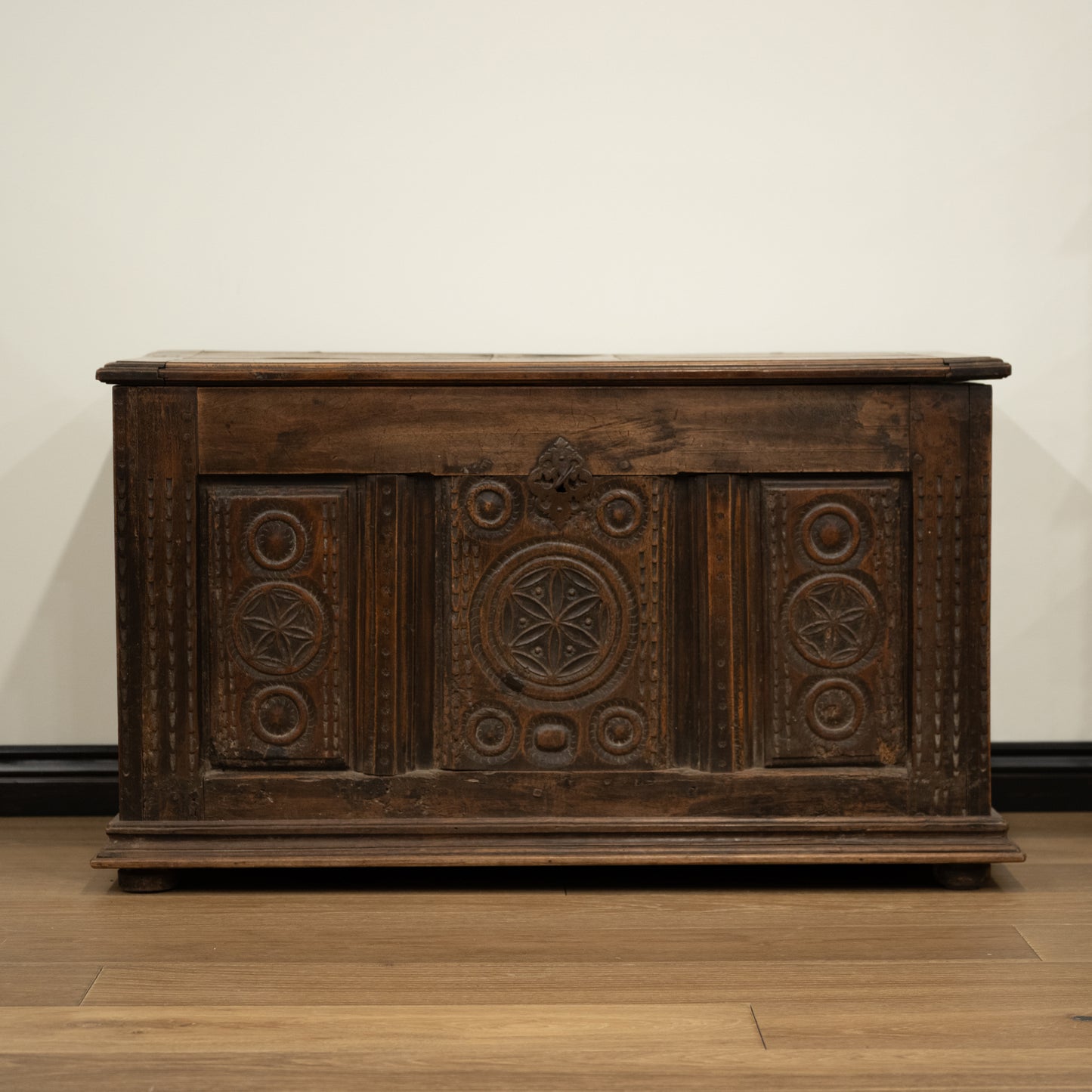 Dark brown 19th century french wooden mountain chest with intricate carved patterns and rustic worn finish