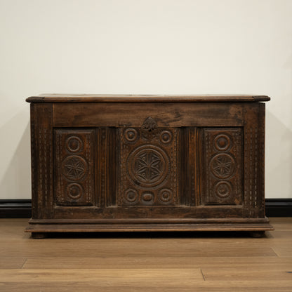 Dark brown 19th century french wooden mountain chest with intricate carved patterns and rustic worn finish