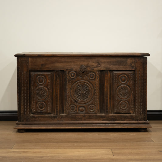 Dark brown 19th century french wooden mountain chest with intricate carved patterns and rustic worn finish