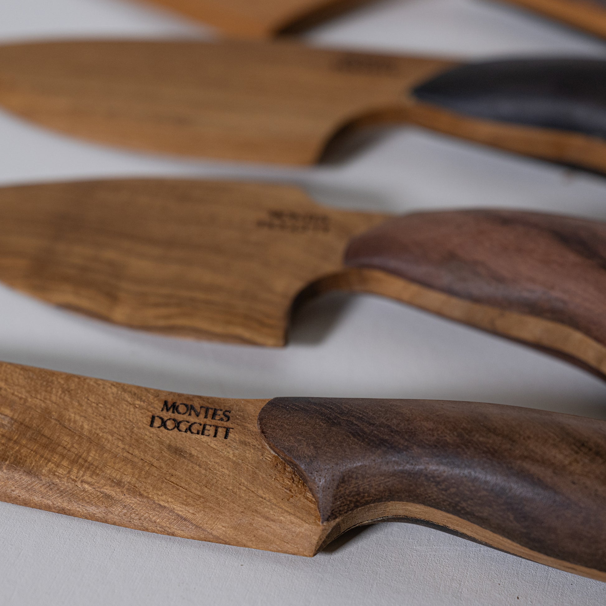 Wooden teak and sono kitchen knives with natural grain handles and dark brown textured grips for cooking use