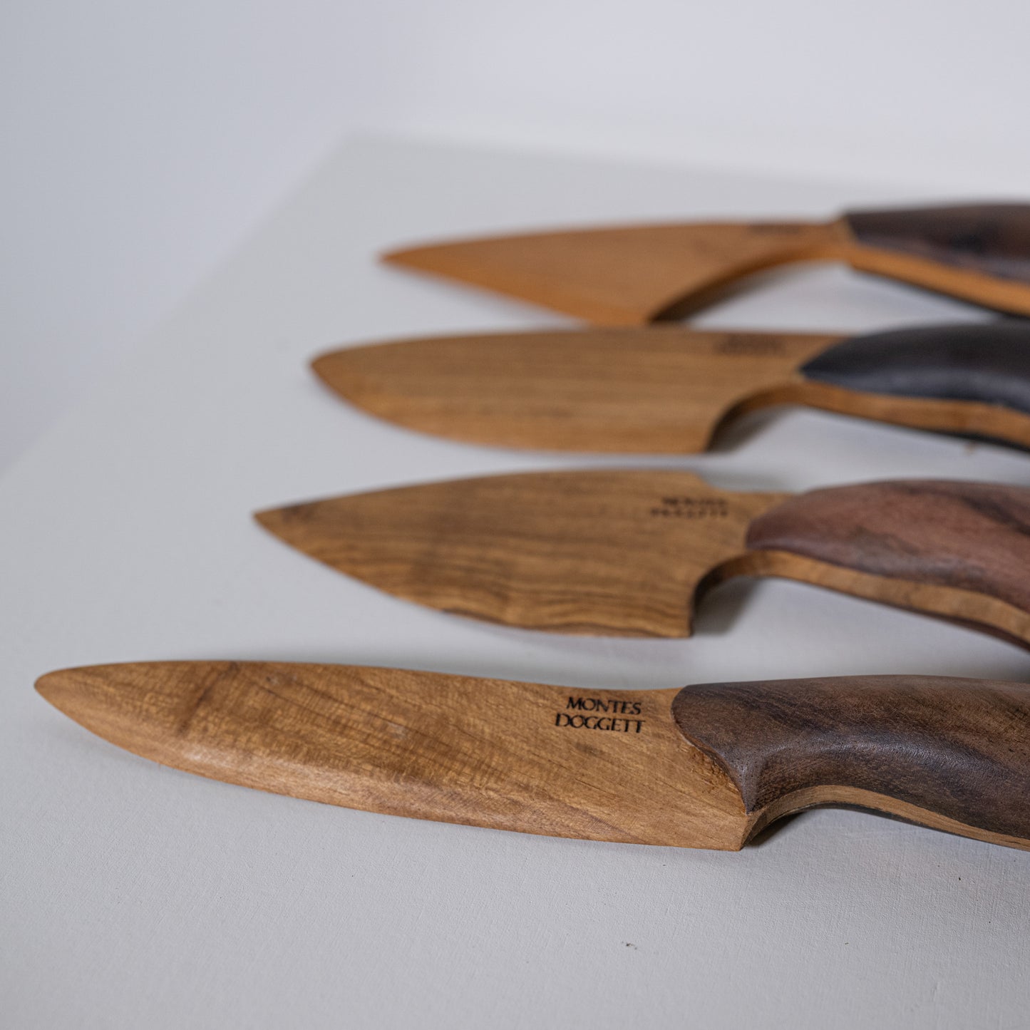 Wooden-handled teak and sono kitchen knives with natural wood grain blades and dark brown handles by montes doggett