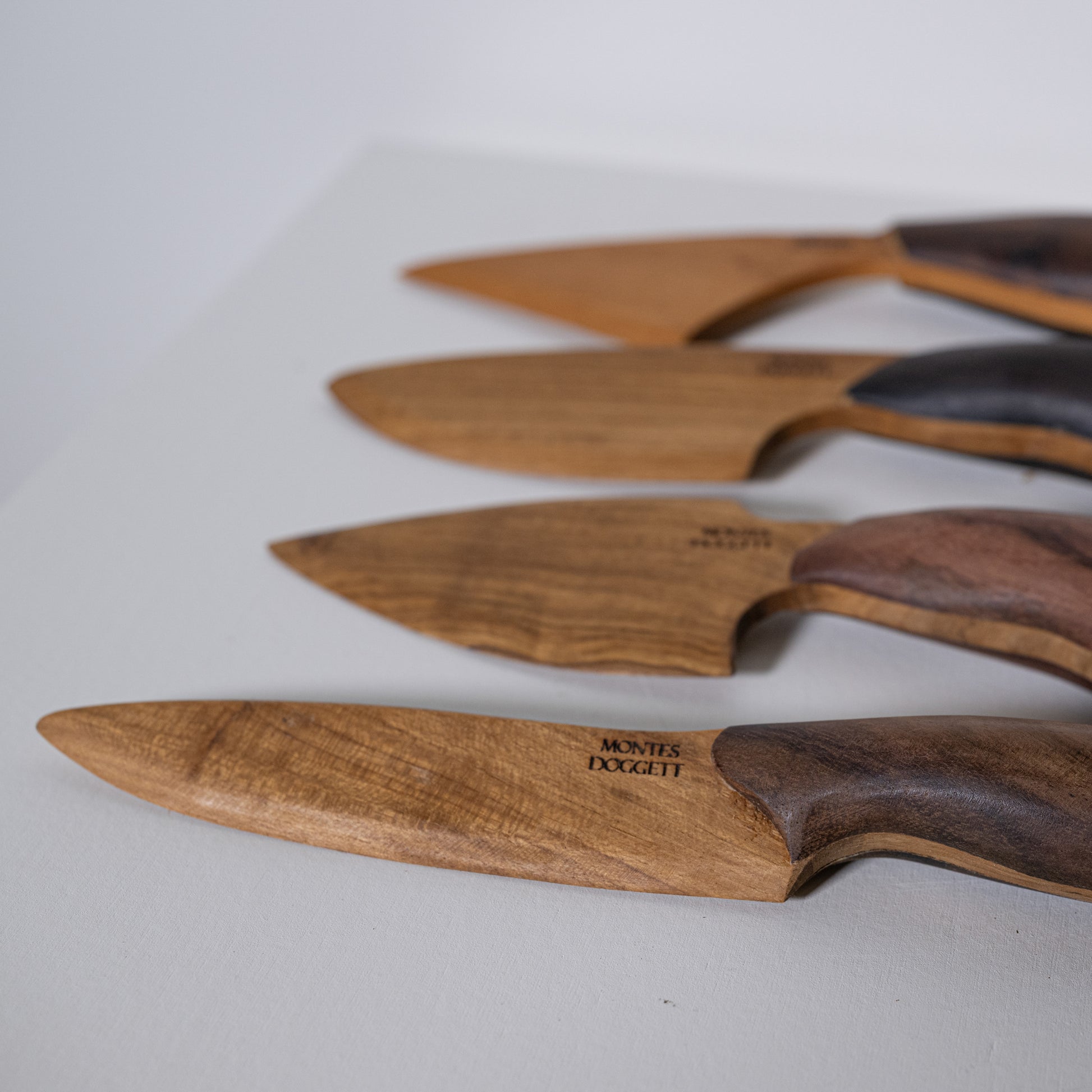 Wooden-handled teak and sono kitchen knives with natural wood grain blades and dark brown handles by montes doggett